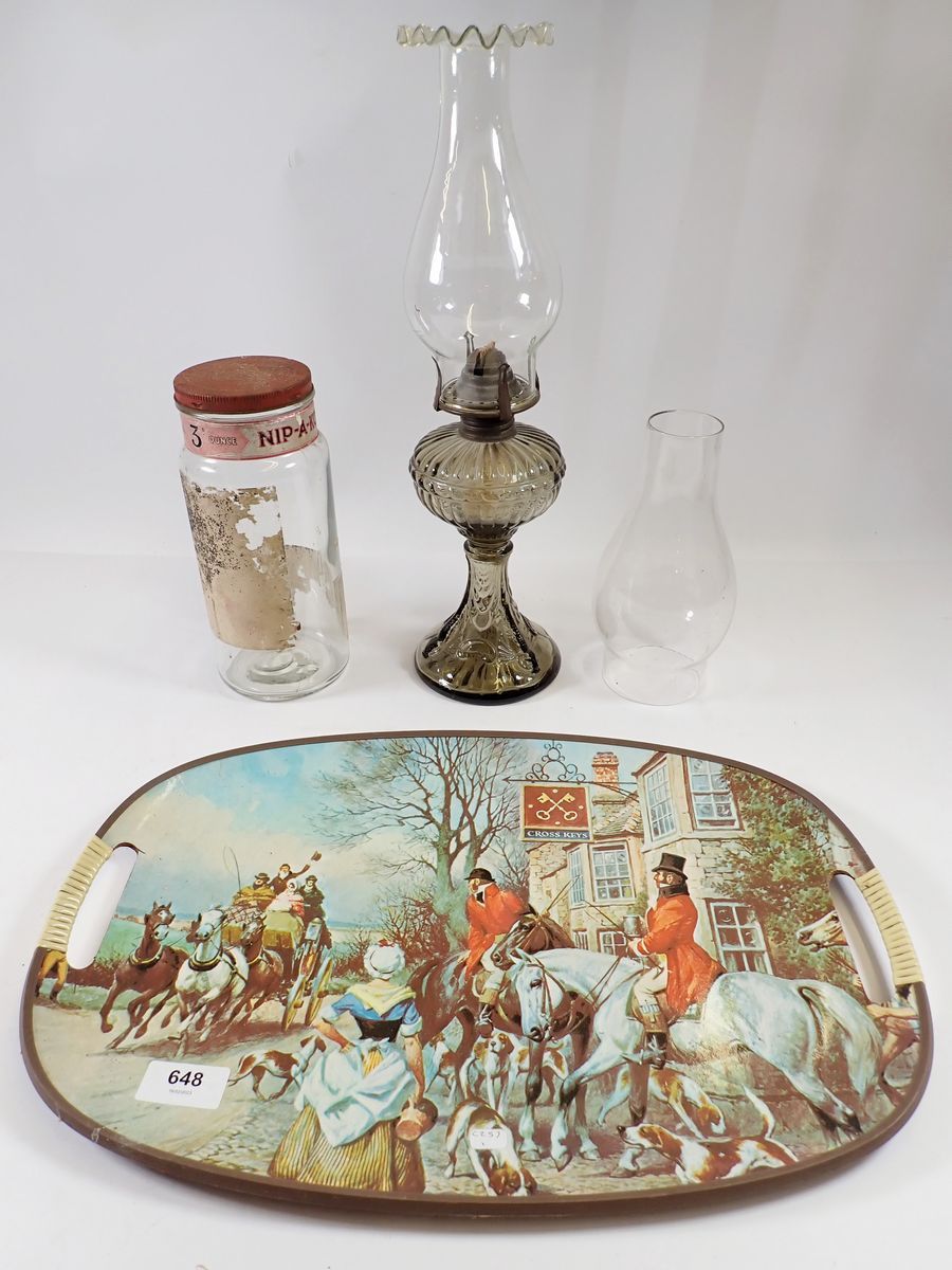 A vintage tray printed hunting scene, a vintage Nip-A-Kofs sweet jar and an oil lamp with glass