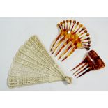 A carved bone fan and two hair combs