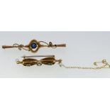 An Edwardian 9 carat gold bar brooch boxed and a yellow metal bow form brooch set green stones