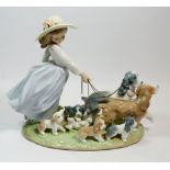 A large Lladro group of girl walking dogs and puppies, 25cm tall