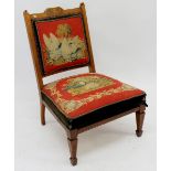 A Victorian mahogany nursing chair with marquetry decoration and original tapestry seat and back