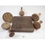 A box of antique butter stamps, pastry wheels and carved wooden cow mould