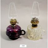 A Victorian purple glass finger lamp and a clear glass one