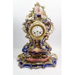 A 19th century porcelain mantel clock and stand in the style of Jacob Petit with elaborate floral
