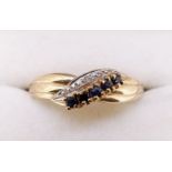 A 9 carat gold ring crossover set line of sapphires, size T, 2g