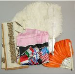 An ostrich feather and mother of pearl fan, an orange feather and bone fan and two scarves