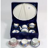A miniature tea service, boxed and three miniature cups and saucers