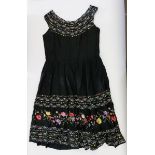 A vintage black satin dress with embroidery panels