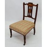 An Edwardian mahogany and marquetry nursing chair on castors
