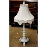 A white painted table lamp on scrollwork base, 79cm tall