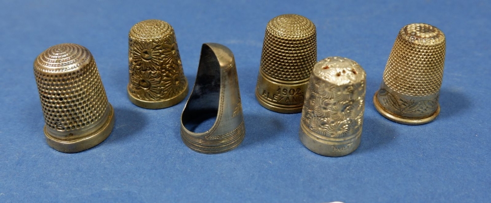 A group of six white metal thimbles including a Coronation of Edward VII 1902 example and an open