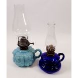 An opaque floral glass finger lamp and a blue glass one