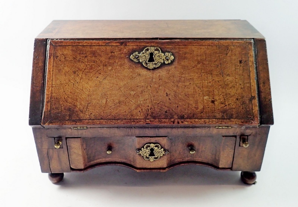 A George II oak slope front miniature cabinet fitted drawers, possible the base to a toiletry