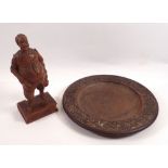 A Black Forest carved wooden figure of a man, 20cm tall and a carved wooden plate