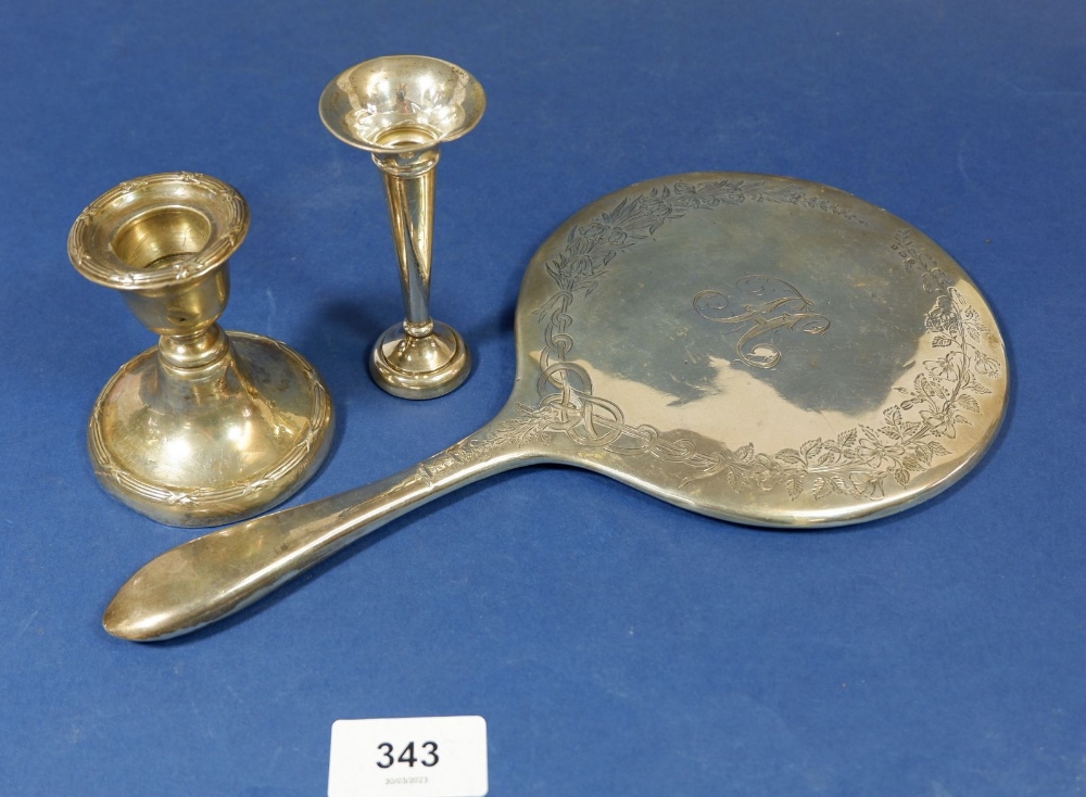 A silver candlestick, silver bud vase and silver hand mirror frame (glass missing)