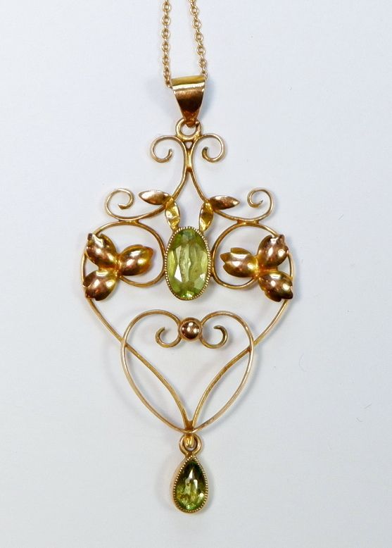 An Edwardian 9 carat gold openwork pendant set peridot on yellow metal chain, 2.4g