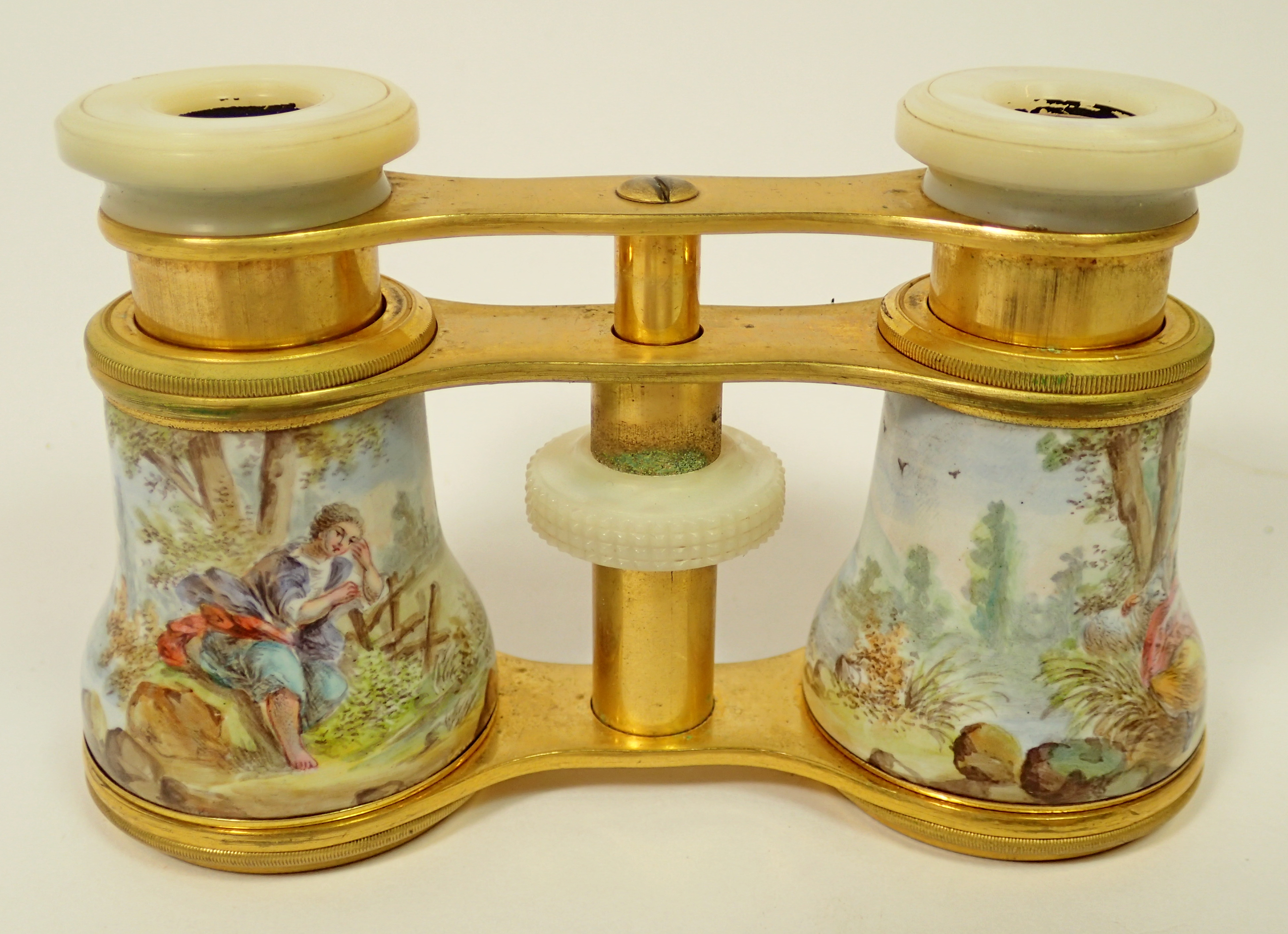 A pair of late 19th century enamelled opera glasses decorated rococo landscape scenes with mother of