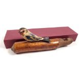 An early 20th century natural wood whistle with carved and applied goldfinch, 16cm