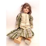 A German bisque headed doll 'Welsch' No 7 with jointed composition body, with brown hair and