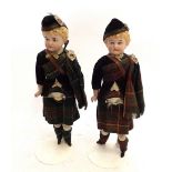 A pair of bisque porcelain dolls in Scottish costumes, 27cm tall