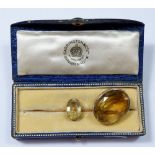 A gold bar brooch set citrine, cased, by Carrington & Co and an oval gold framed citrine brooch,