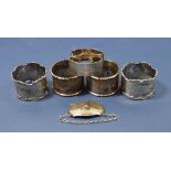 Five silver napkin rings and a decanter label, 157g