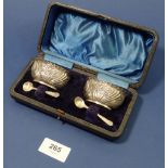 A pair of oval silver embossed salts and spoons cased, 54g