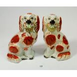 A pair of Victorian Staffordshire spaniels with baskets of flowers, 19cm tall
