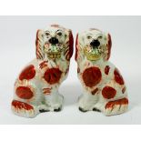 A pair of Victorian Staffordshire spaniels with baskets of flowers, 19cm tall