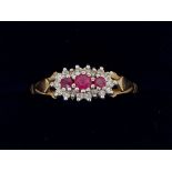 A 9 carat gold ring set three rubies within chip diamond surround, size R, 1.6g