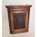 An oak corner cupboard with carved 'Green Man' mask to door