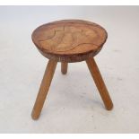 An elm tripod milking stool with decorated leather top, 34cm high