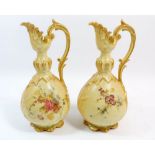 A pair of D & C Limoges ewers in the style of Worcester painted flowers on an ivory blush ground,