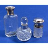 Three silver and cut glass scent and toiletry bottles