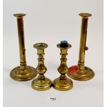 A pair of brass candlesticks with pushers, 22cm and another pair of brass candlesticks