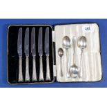 Five silver handled tea knives in case plus four silver spoons, 81.5g