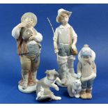 A collection of four Lladro figures including boy with polar bear, cat and mouse, fisherman and