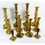 Six pairs of antique brass candlesticks