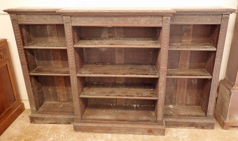 A 19th century dwarf oak breakfront bookcase with all over floral carved decoration and pilasters to