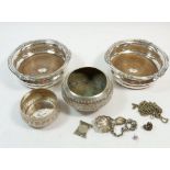 A pair of silver plated and wooden bottle coasters, two Indian white metal embossed bowls, caddy