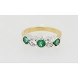 An 18 carat white and yellow gold ring collet set two diamonds and three emeralds (Emeralds .