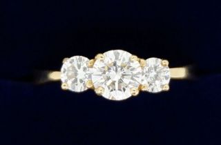 An 18 carat gold three stone diamond ring, the centre stone approx. 1/2 carat, colour GH, clarity