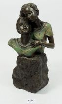 A resin sculpture of man and woman, signed Genesis, 28cm tall