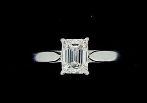 A fine platinum set solitaire diamond ring, the emerald cut stone 1.06 cts, size M to N, with FGA