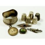 A group of silver items including a Poetry Society medal, three brooches, five thimbles and a napkin