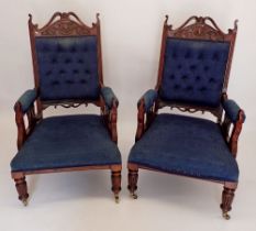 A pair of Victorian carved frame mahogany salon chairs with blue upholstery