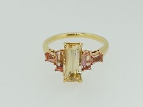 An 18 ct gold ring set central step cut yellow topaz flanked by two pairs of step cut pink topaz,