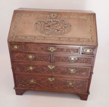 An early 18th century bureau with all over finely carved decoration including hunting scene, foliage