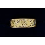 A 9 carat gold ring with stylised leaf and flower decoration (originally enamelled) 2.5g, size M