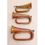 A Barratts & Co brass military bugle and two copper ones